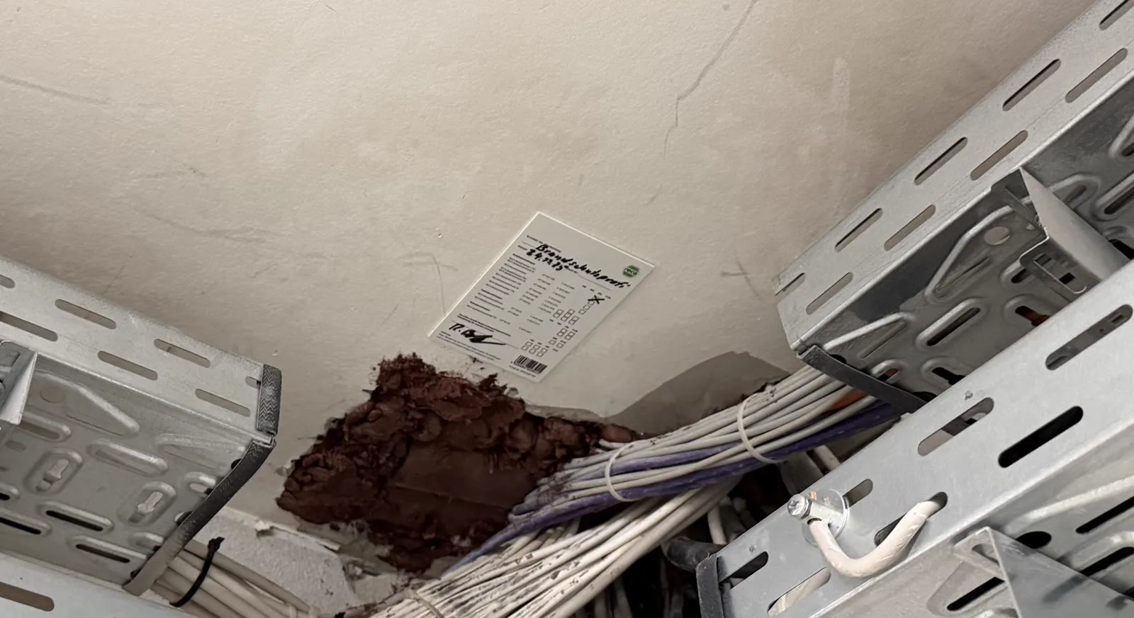 Kabeltrasse durch eine Wand mit Weichschott und angebrachtem Kennzeichnungsschild